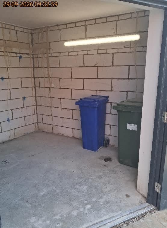 The same bin store at Arrowsmith Court, Thame, cleared and swept with only the wheelie bins left